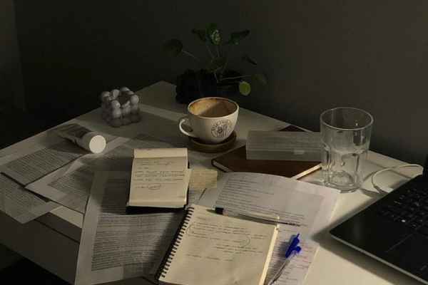 A quiet desk with a notebook and a warm drink in natural light